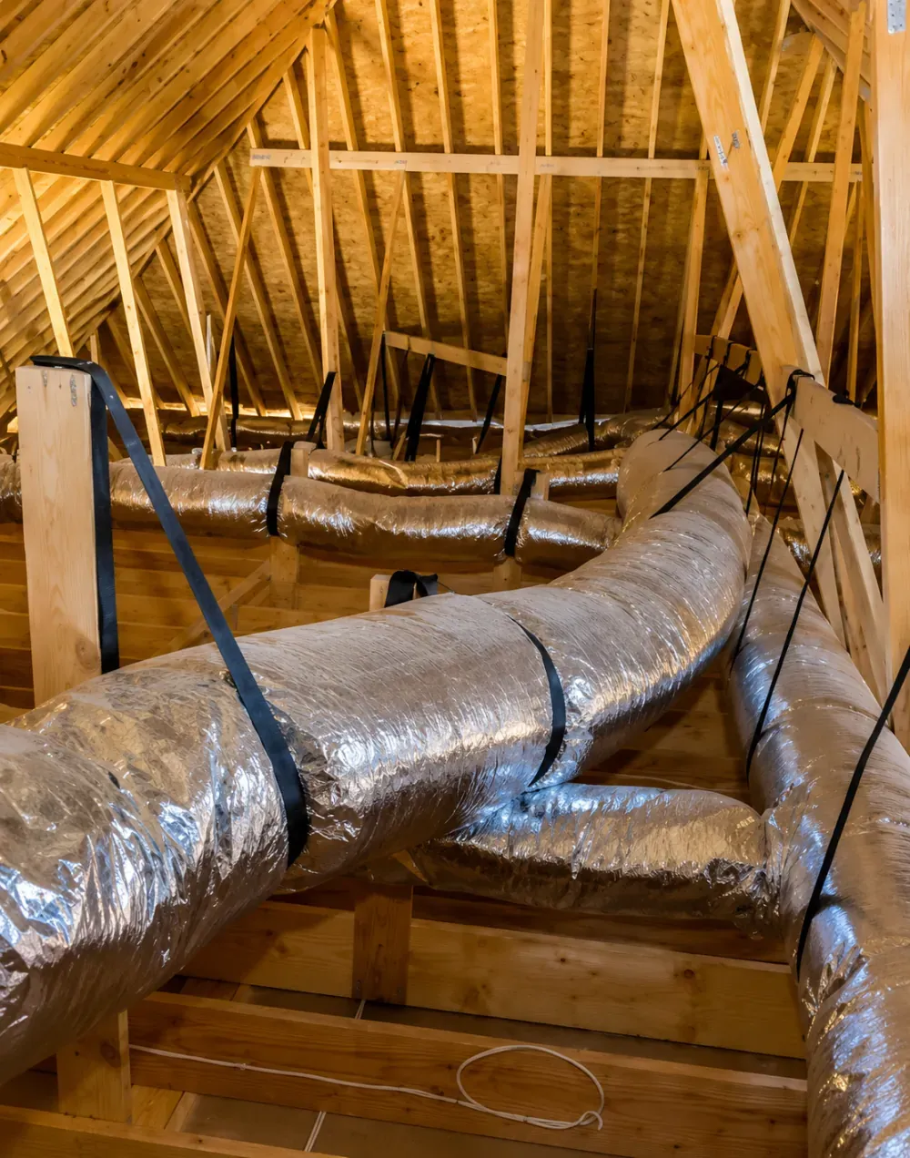 Attic interior with roof framing and insulated ductwork