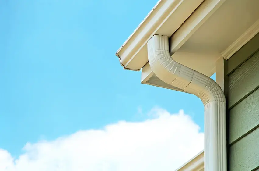 Seamless gutter and downspout diverting rainwater on a Austin home