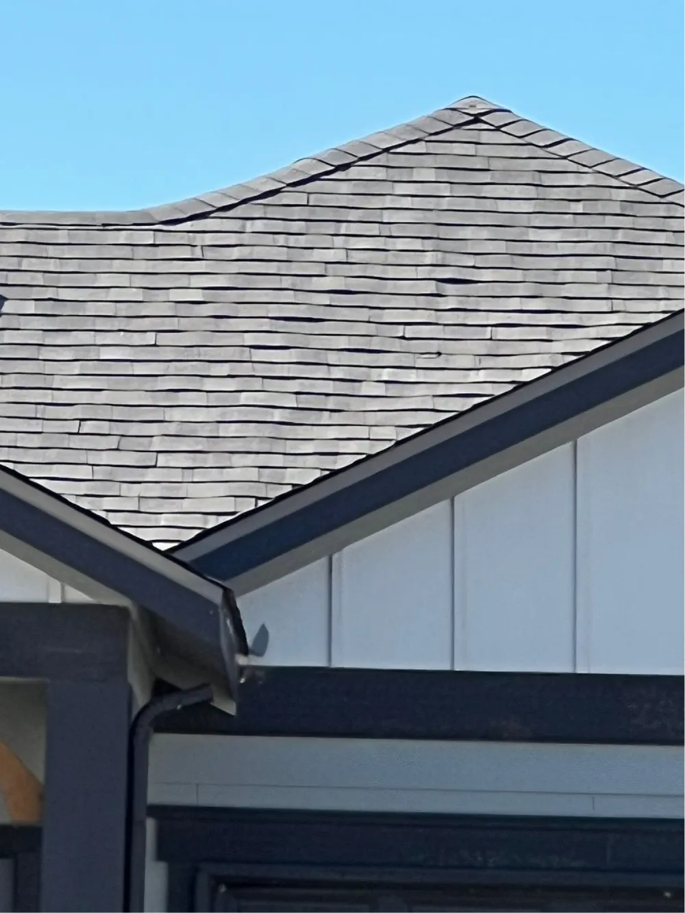 Gray shingle roof and gutter detail showing roof surfaces that affect summer cooling costs
