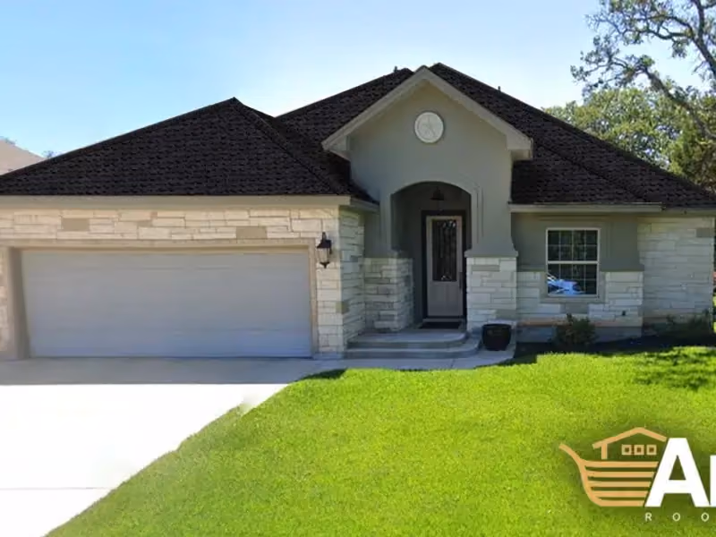 Dark shingle roof above light stone and trim on a home