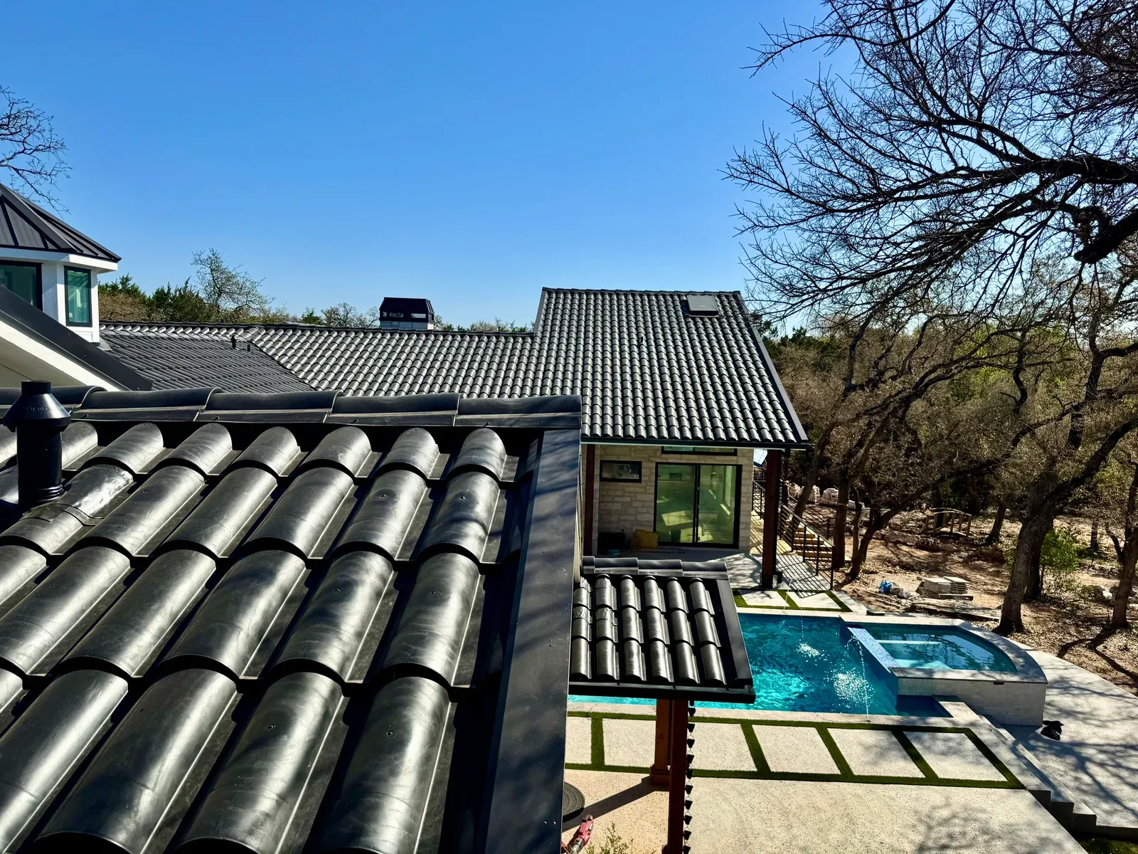 Gutter line running along a Central Texas roofline under open sun